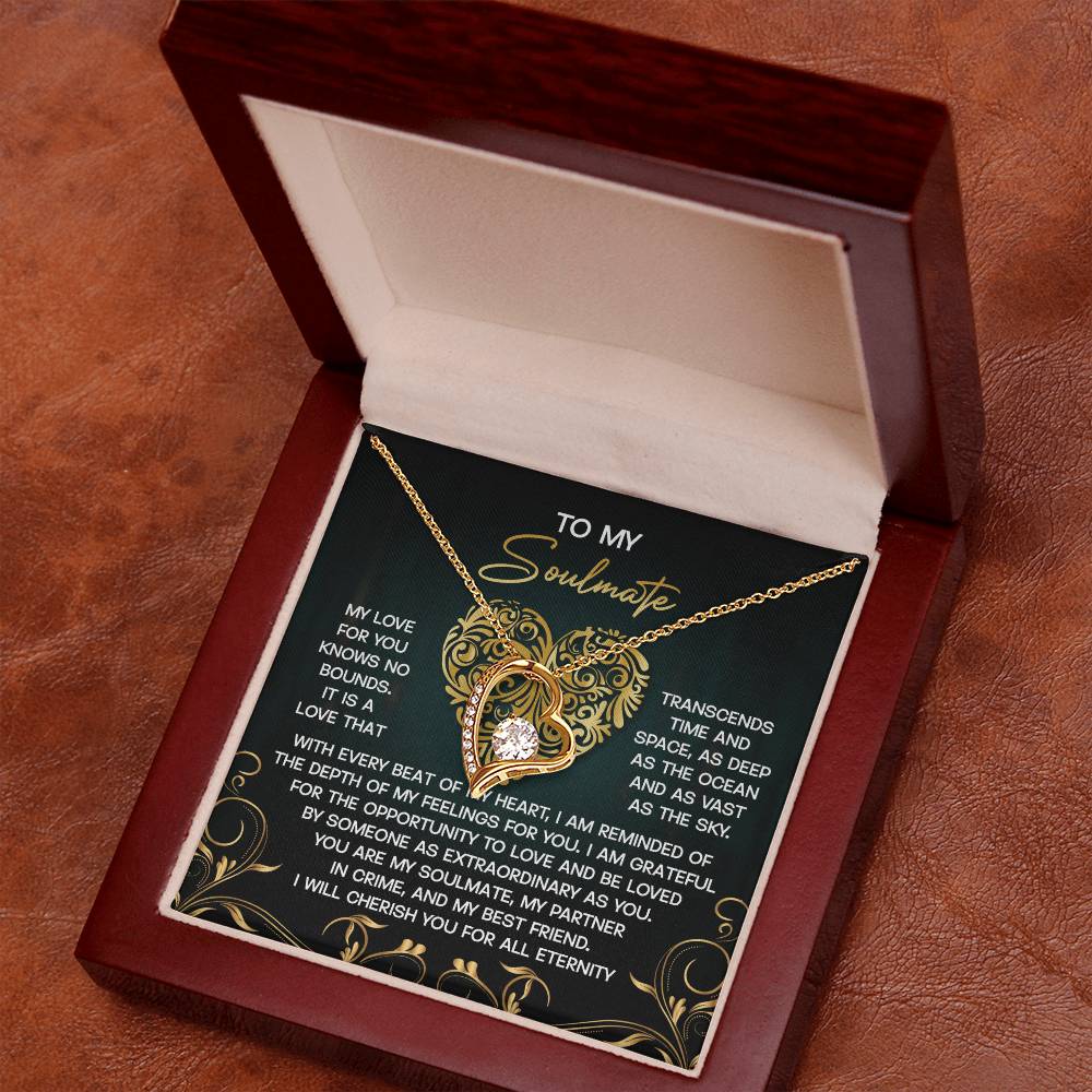 An open wooden box reveals the Soulmate-The Sky - Forever Love Necklace, featuring a heart-shaped gem with a dazzling CZ crystal set in gold finish, elegantly displayed on a decorative card with a romantic message.