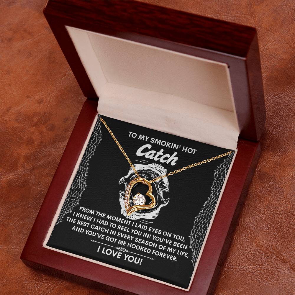 Nestled in a jewelry box, the Soulmate-Got Me Hooked - Forever Love Necklace showcases a heart pendant with sparkling CZ crystals and a radiant white gold finish. Background text reads: "To my smokin' hot catch... I love you.