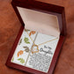 The Daughter-Biggest Fan - Forever Love Necklace features a heart-shaped pendant with a gold finish and sparkling CZ crystal. It arrives beautifully nestled in a wooden box, accompanied by a heartfelt message card for your daughter, elegantly decorated with leaf patterns.