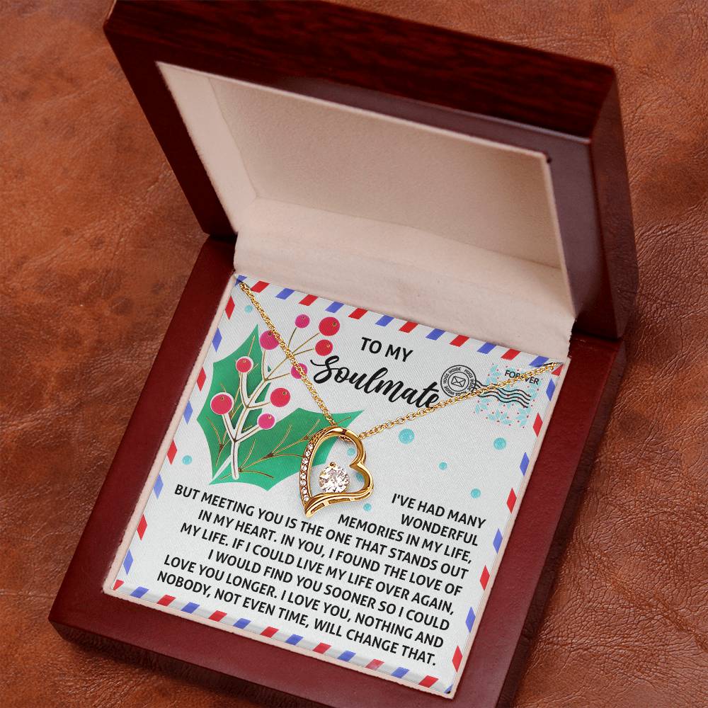 The Soulmate-Love You Longer - Forever Love Necklace, a gold heart-shaped piece, rests elegantly in an open wooden box. A heartfelt message on a colorful card accompanies it, symbolizing timeless devotion and adorned with sparkling cubic zirconia for that added touch of brilliance.