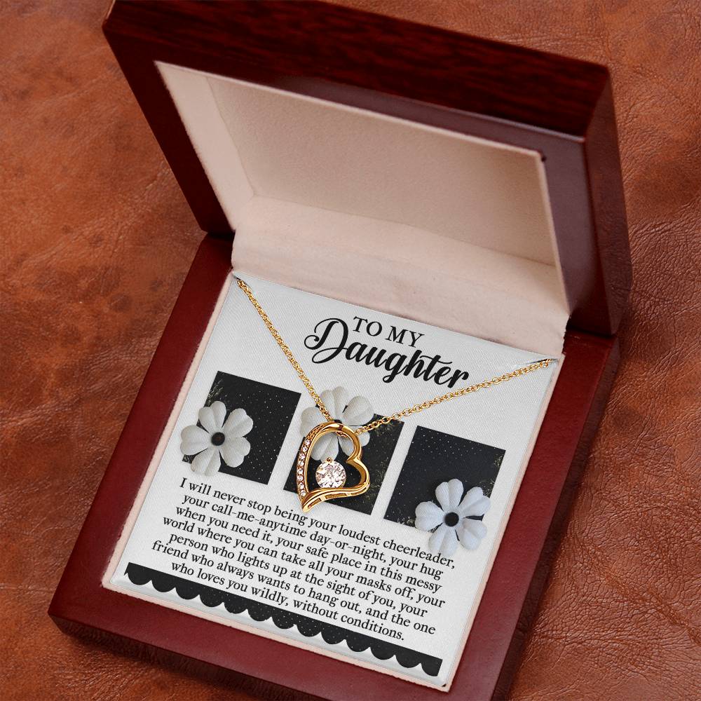 The Daughter-Loudest Cheerleader - Forever Love Necklace is an exquisite heart-shaped gold piece adorned with CZ crystals and a white gold finish. It is elegantly packaged in a wooden box along with a "To My Daughter" card, embellished with flowers and conveying a heartfelt message.