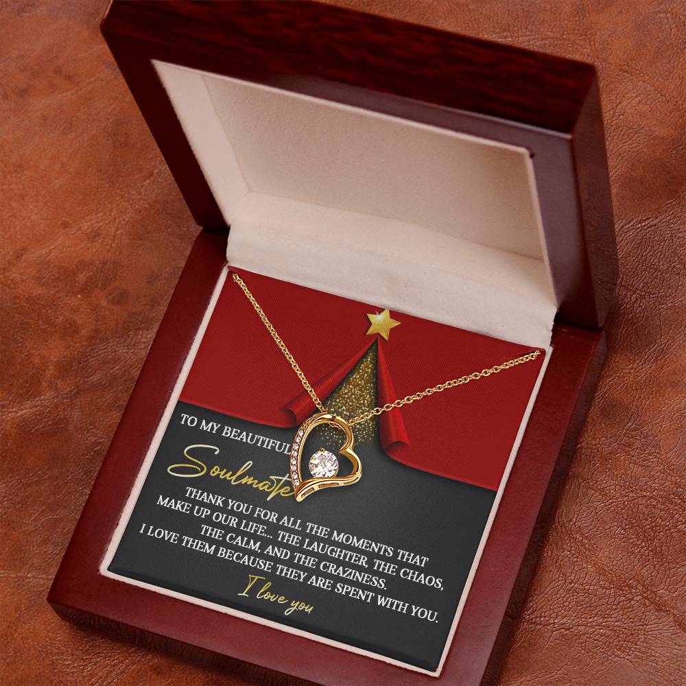 The Soulmate-The Moments - Forever Love Necklace showcases a heart-shaped design highlighted by a dazzling cubic zirconia stone at its center, all elegantly finished in white gold. It is beautifully presented in a wooden box with the lid featuring a romantic message and festive graphics of a Christmas tree and star.