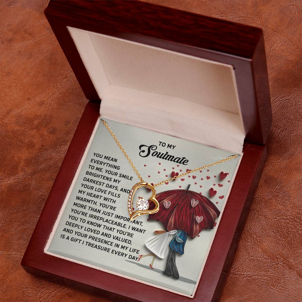 The Soulmate-Deeply Loved - Forever Love Necklace features a heart pendant with a white gold finish, nestled in a jewelry box. Inside the lid is a touching message and illustration of a couple under a red umbrella, making it an enchanting gift.