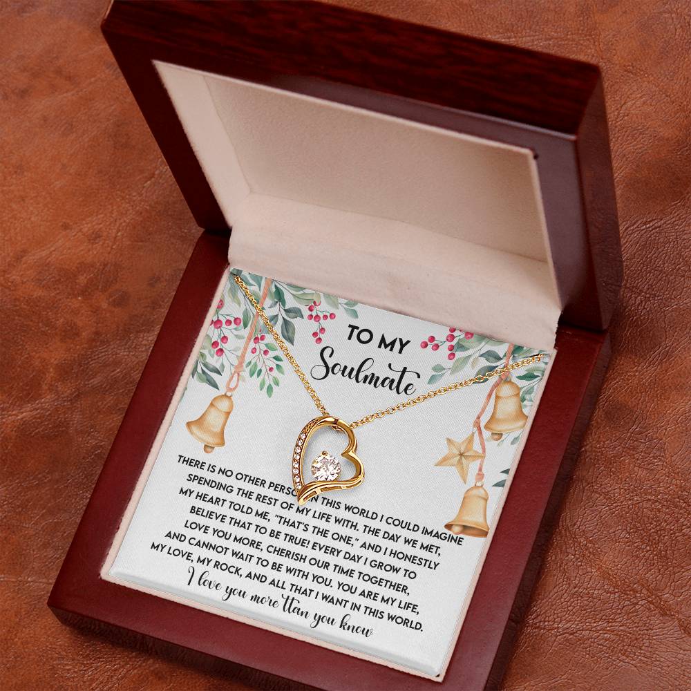 An open wooden box containing the Soulmate-Be With You - Forever Love Necklace, which features a heart-shaped pendant. The interior is adorned with printed text and floral designs, complemented by a breathtaking gold finish that accentuates the sparkle of the cubic zirconia on the necklace beautifully.