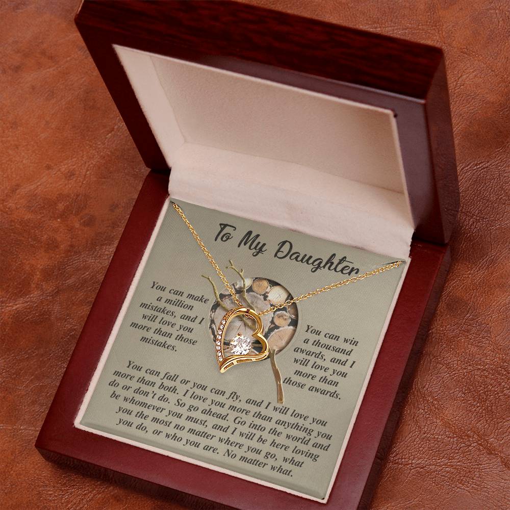 The Daughter-A Thousand Awards - Forever Love Necklace, featuring a gold finish and a heart pendant adorned with CZ crystal, is beautifully presented in an open wooden box. It lies on a touching note titled "To My Daughter," delivering an inspirational message to treasure always.