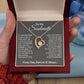 A person holds a gift box containing a heart-shaped ShineOn Fulfillment Forever Love Necklace with a gold finish and cubic zirconia, and an emotional message for a soulmate engraved inside the lid.