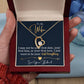 A person holding a gift box with a ShineOn Fulfillment Forever Love Necklace, featuring a heart-shaped cubic zirconia pendant and an affectionate message from a husband to his wife.