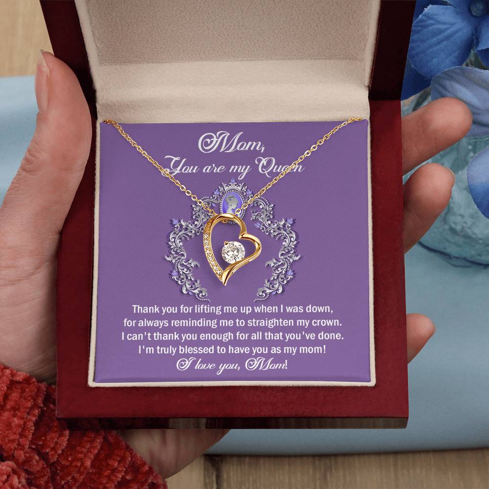 A person holds an open jewelry box containing the "To Mom, Belongs To Me - Forever Love Necklace," a heart-shaped pendant adorned with cubic zirconia and accompanied by a heartfelt message expressing gratitude and love, beautifully conveying emotions in a timeless fashion.