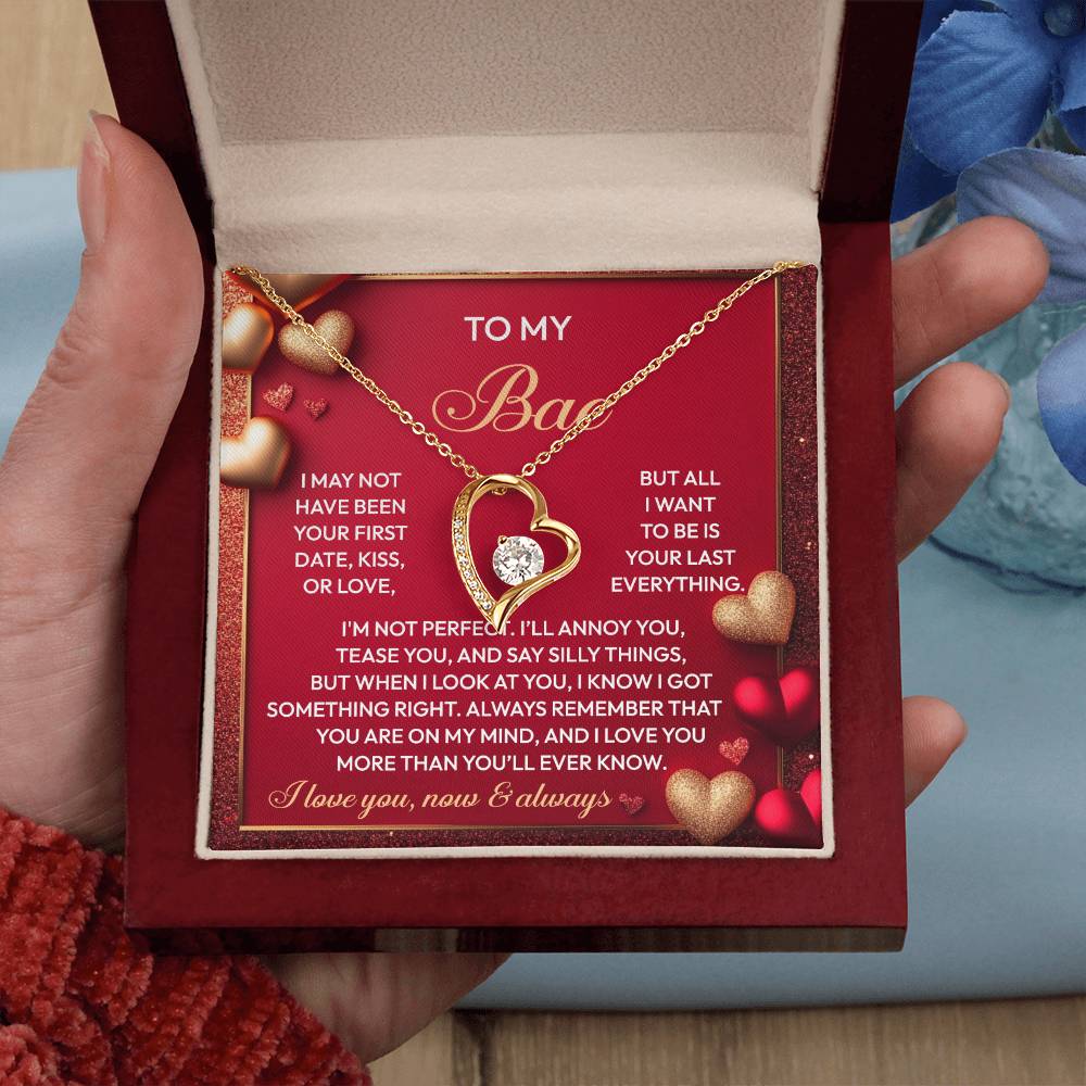 A hand presents an open box revealing the "Soulmate-On My Mind - Forever Love Necklace" featuring a heart-shaped pendant in a glittering white gold finish. The lid showcases a romantic message with heart embellishments, symbolizing eternal love.