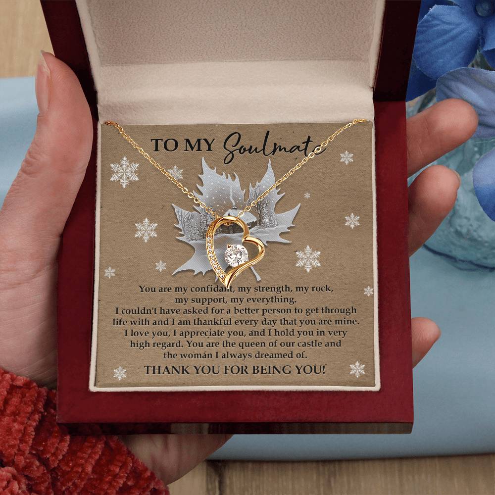 A hand holds an open box containing the Soulmate-Our Castle - Forever Love Necklace, showcasing a heart-shaped pendant adorned with shimmering cubic zirconia and a white gold finish. Inside, the card carries a heartfelt message addressed to "My Soulmate.