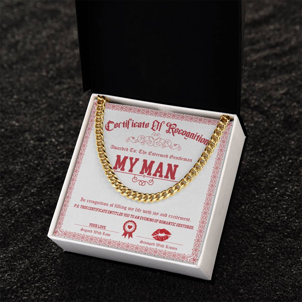 Gold Cuban Link Chain on black cushion inside a box, resting on a certificate labeled "My Man-Esteemed Gentleman" with decorative text and graphics.