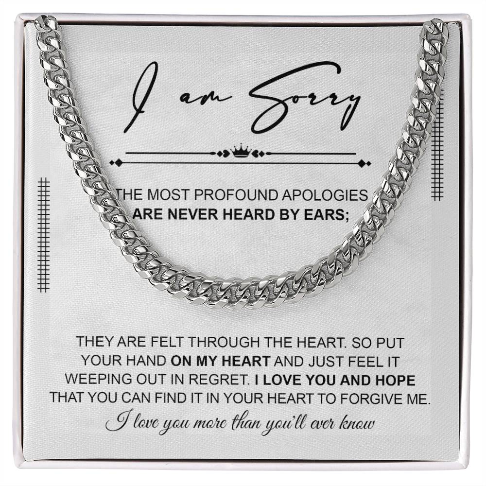 A polished stainless steel Cuban Link Chain necklace with an apology note. The note reads: "I am sorry. The most profound apologies are never heard by ears; they are felt through the heart... I love you and hope you can forgive me.