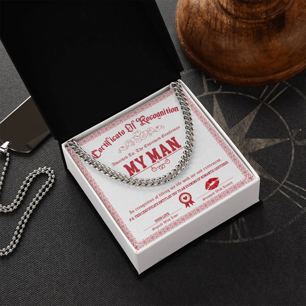 The My Man-Esteemed Gentleman Cuban Link Chain, crafted from polished stainless steel, elegantly rests in an open black box with a printed certificate featuring "My Man" in bold red.