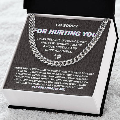 The "Sorry, Hurt You Badly - Cuban Link Chain," crafted in 14K yellow gold, is elegantly presented on a black gift box. The box features an apology message printed in white text, expressing regret for selfish actions, acknowledging wrongdoing, and asking for forgiveness.