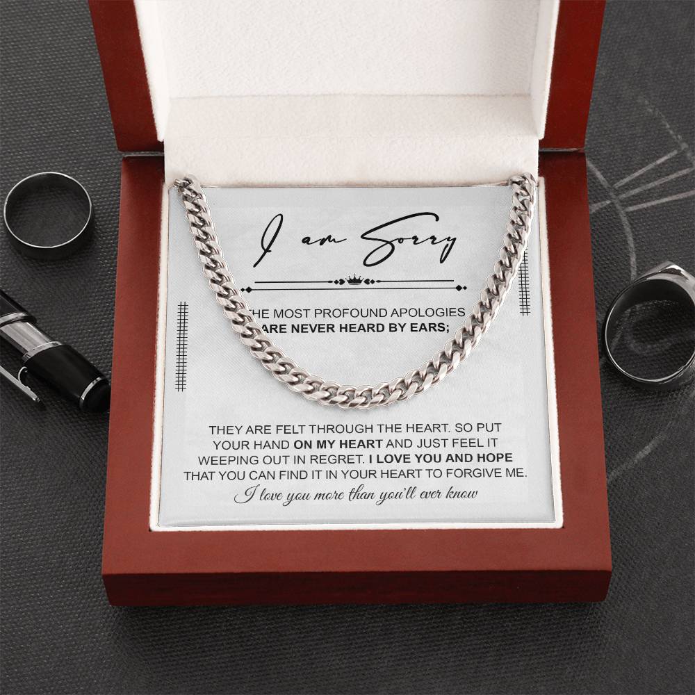 A polished stainless steel Cuban Link Chain necklace with an apology note. The note reads: "I am sorry. The most profound apologies are never heard by ears; they are felt through the heart... I love you and hope you can forgive me.