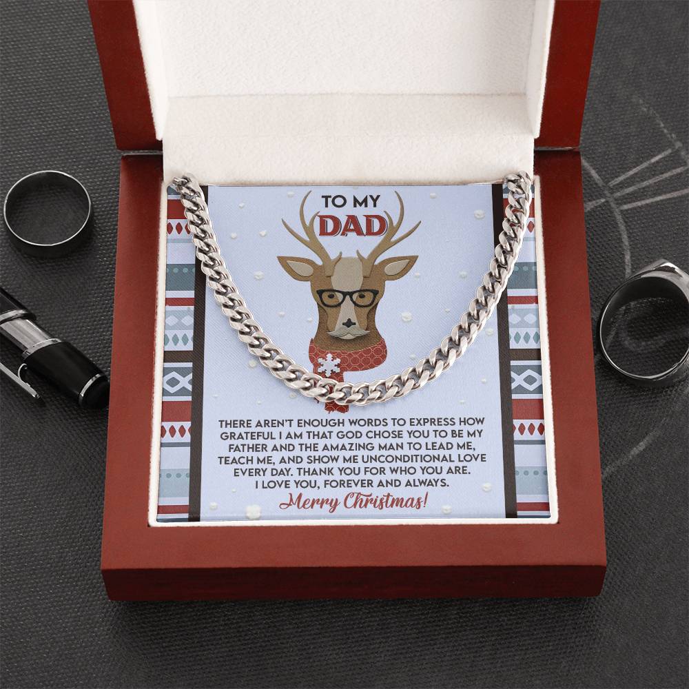 The "Dad-Be My Father - Cuban Link Chain" is elegantly displayed in a red gift box, complemented by a card with a reindeer wearing glasses that conveys heartfelt Christmas wishes to Dad. This personalized necklace, alongside two rings and a pen on the table, serves as a thoughtful gift for any occasion.