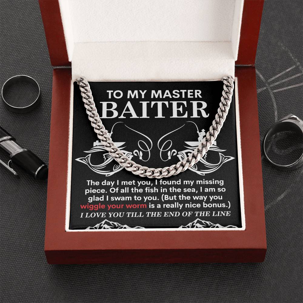 The My Man-In The Sea - Cuban Link Chain, made from polished stainless steel, sits in an open box with a message "To my master baiter," along with a note about finding missing pieces, wiggling worms, and love. It is surrounded by rings and a gleaming pen.