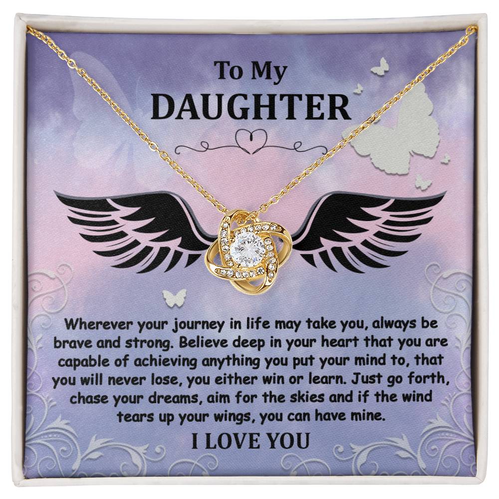 The "To Daughter, Brave And Strong - Love Knot Necklace" features a gold finish and a Cubic Zirconia pendant, beautifully displayed in a box. The box contains a heartfelt message titled "To My Daughter," encouraging bravery, strength, and the pursuit of dreams, and concludes with the words "I LOVE YOU.