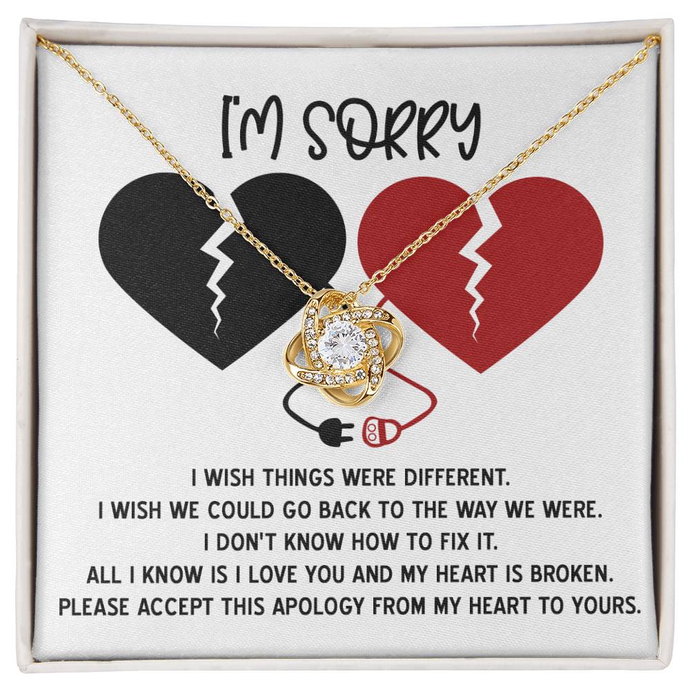 The "Sorry-Heart Is Broken - Love Knot Necklace" features an intertwined heart and infinity design, adorned with cubic zirconia crystals. It is displayed on a card with two broken hearts and a heartfelt message expressing sorrow and hope for reconciliation, all in a stunning white gold finish.