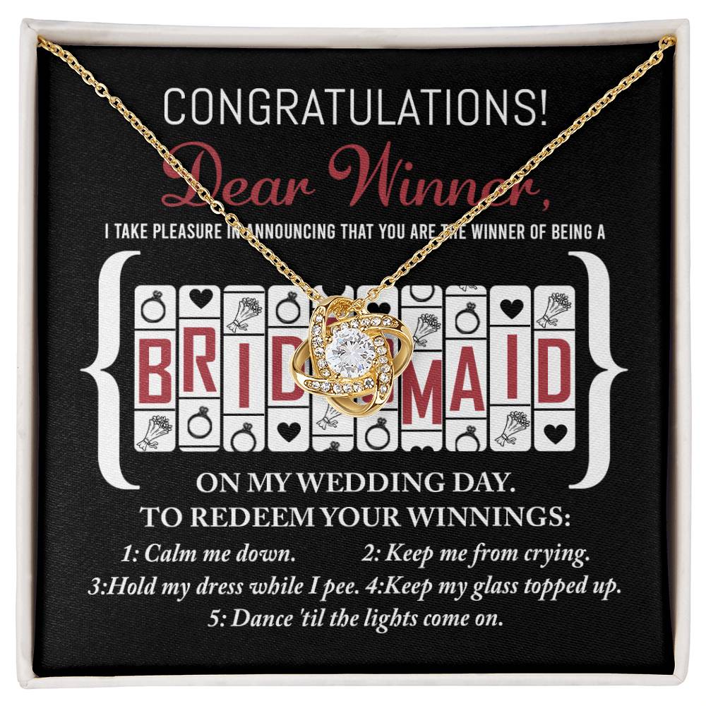 The "To Bridesmaid, The Winner Of - Love Knot Necklace" is beautifully presented on a card that congratulates the recipient on becoming a bridesmaid. The card features five key bridesmaid duties against a black background, symbolizing the unbreakable bond shared through this special role.