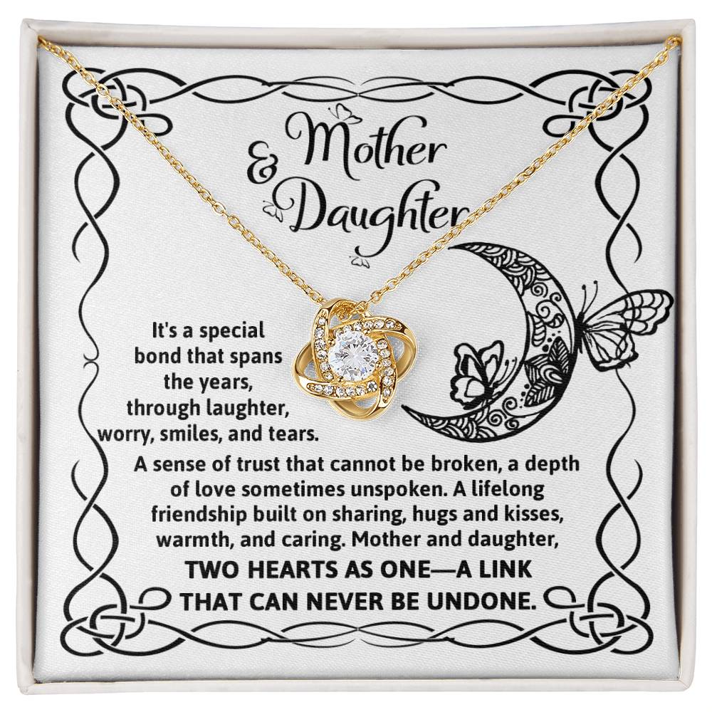 A silver To Daughter, A Special Bond - Love Knot Necklace with an intertwined knot pendant adorned with cubic zirconia crystals, presented on a card with "Mother & Daughter" text, a decorative border, and a heartfelt message about their unbreakable bond.