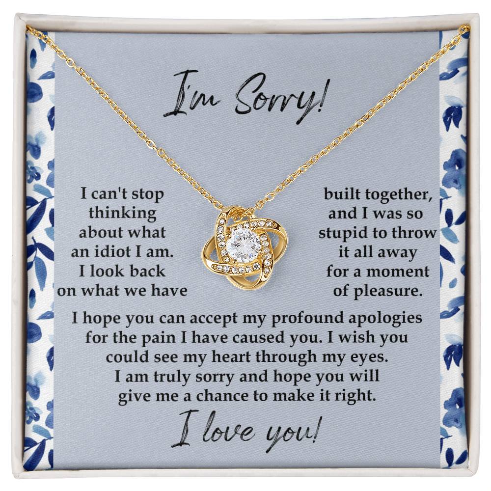 The "Sorry-Through My Eyes - Love Knot Necklace," adorned with cubic zirconia crystals and a white gold finish, is presented on a card featuring a heartfelt apology message, expressing regret for causing pain and seeking forgiveness.