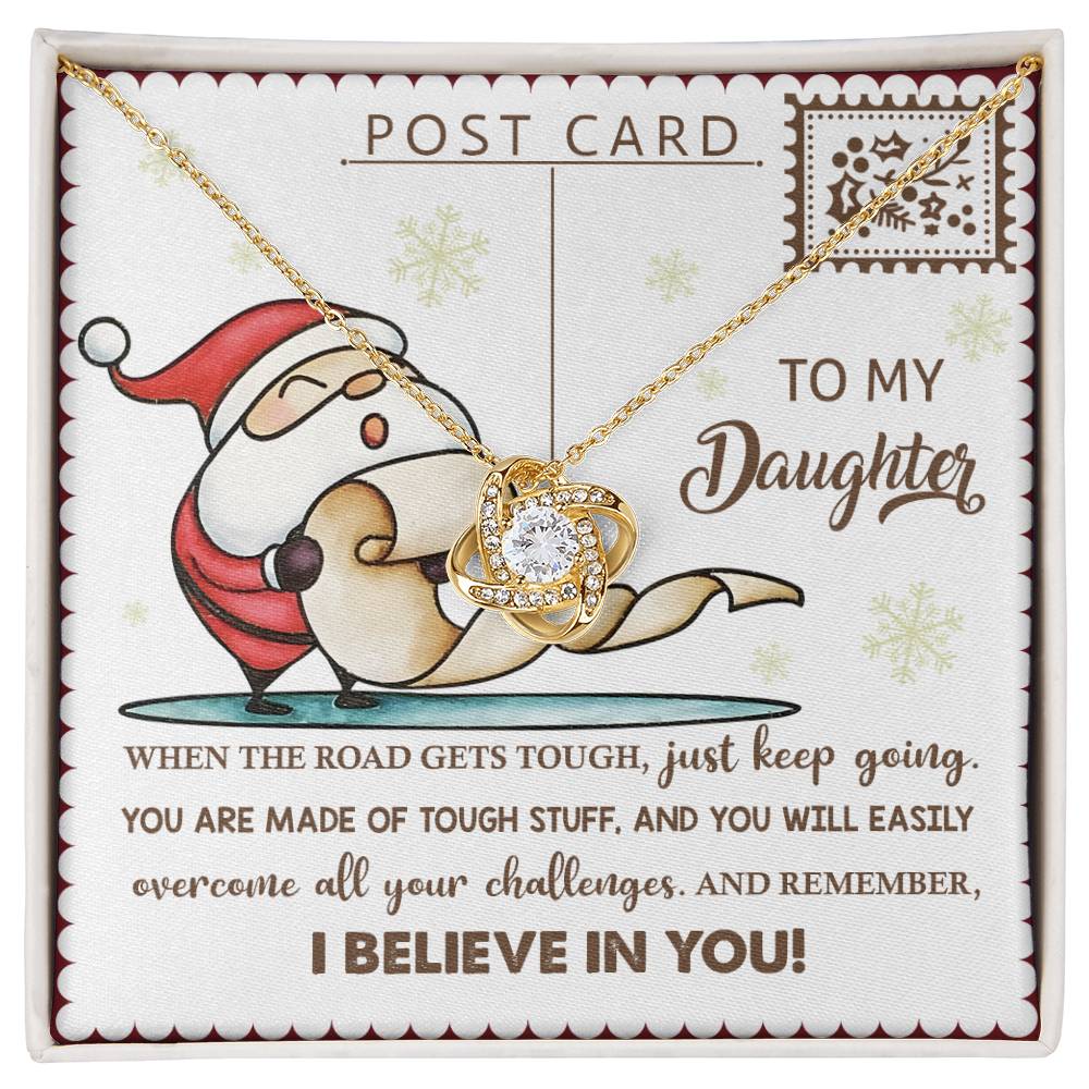 The Daughter-Keep Going - Love Knot Necklace, representing an unbreakable bond, features a delicate setting with cubic zirconia. It is beautifully presented in a gift box that contains a message card adorned with a heartfelt quote for a daughter and an endearing cartoon image.