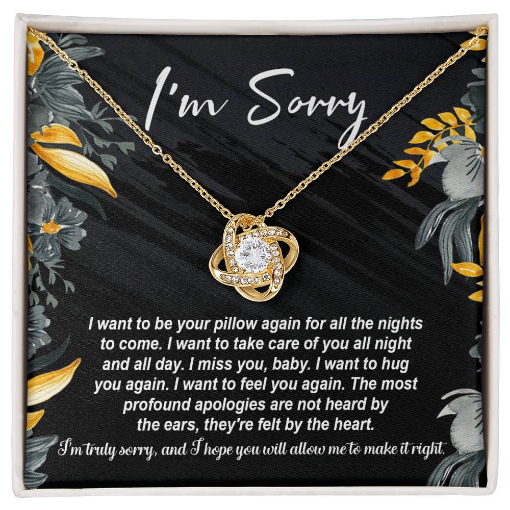 The "Sorry, Be Your Pillow - Love Knot Necklace" features an intertwined heart pendant adorned with cubic zirconia crystals. It comes in a gift box inscribed with "I'm Sorry" and includes a heartfelt apology message expressing regret and a desire for reconciliation.