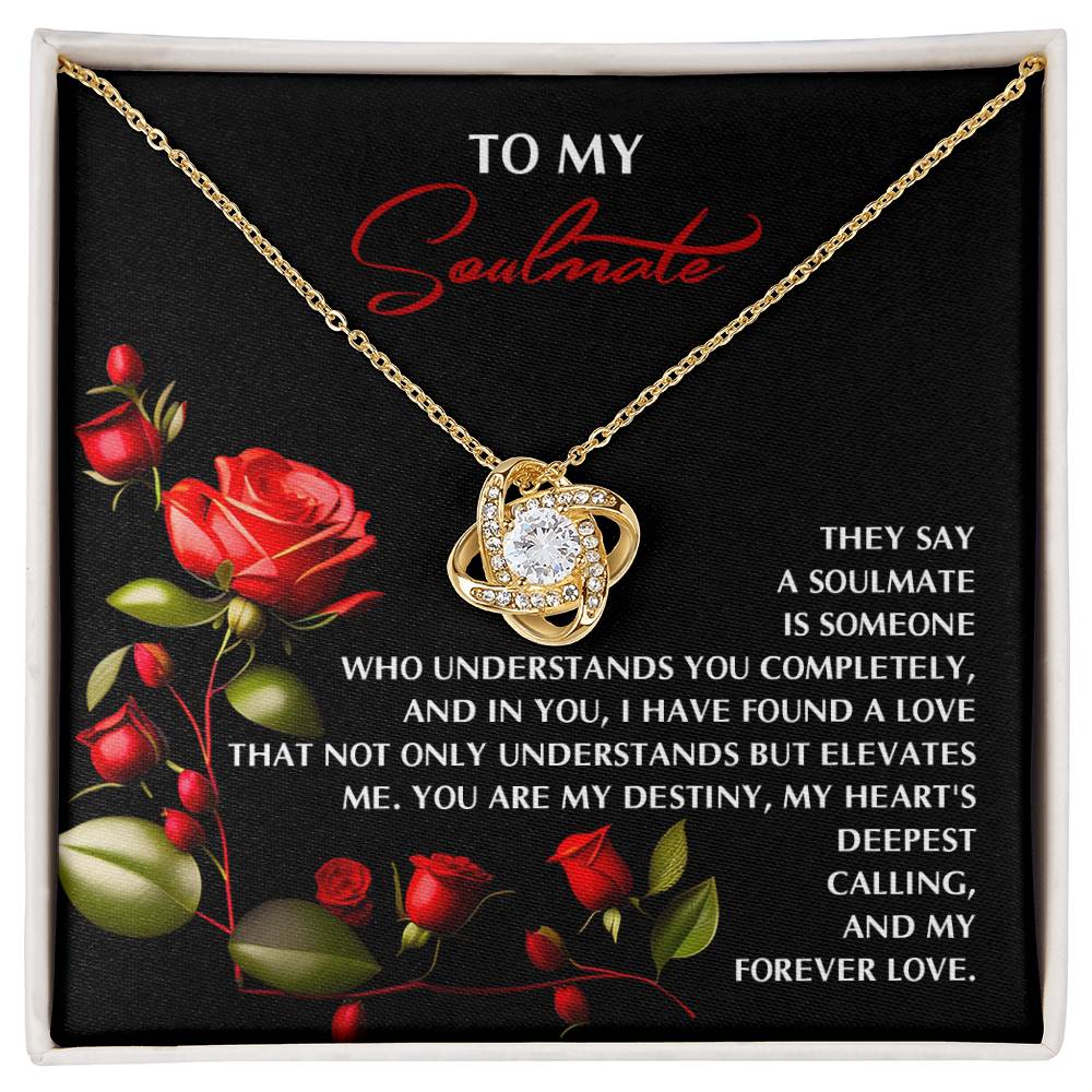 The Soulmate-Deepest Calling - Love Knot Necklace, featuring sparkling cubic zirconia, is displayed against a black background with roses and a touching message: "To my soulmate... You are my destiny, my heart's deepest calling, and my forever love.