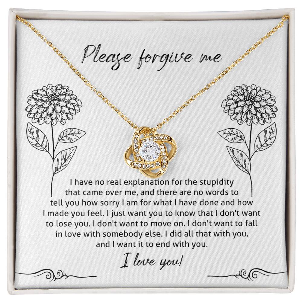 The Sorry-Real Explanation - Love Knot Necklace features an intertwined heart pendant adorned with cubic zirconia crystals, presented in a box. The box lid includes an apology note with floral illustrations, expressing regret, love, and a plea for forgiveness.