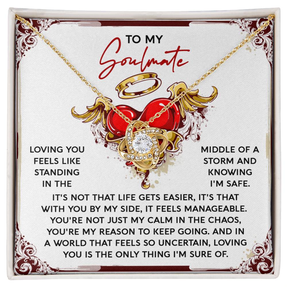 The Soulmate-Keep Going Love Knot Necklace, featuring interlocking hearts and cubic zirconia crystals, is displayed on a card titled "To My Soulmate" with a message about love and support through tough times—an elegant symbol of enduring love with its stunning gold finish.