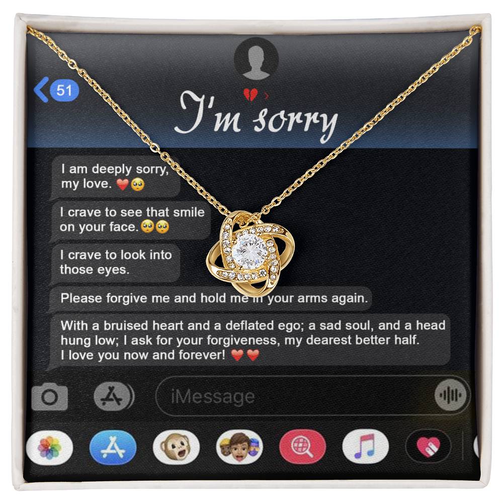 An "I'm sorry" message is displayed on a phone screen along with the stunning Sorry, Rebuild Our Connection - Love Knot Necklace. This necklace, available in either white gold or yellow gold finish and adorned with cubic zirconia crystals, perfectly complements the heartfelt plea for forgiveness.