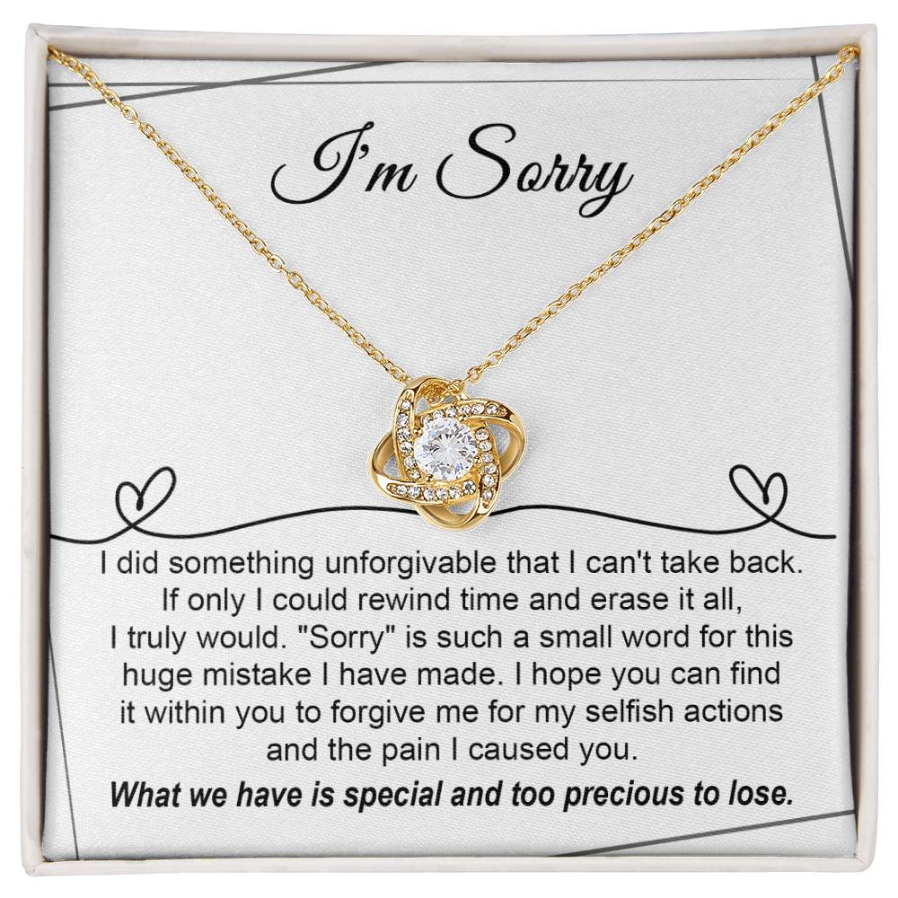 The Sorry-Breaking My Heart - Love Knot Necklace, featuring a gold finish and embellished with sparkling cubic zirconia crystals, is presented on a heartfelt message card that expresses deep regret for a mistake and seeks forgiveness.