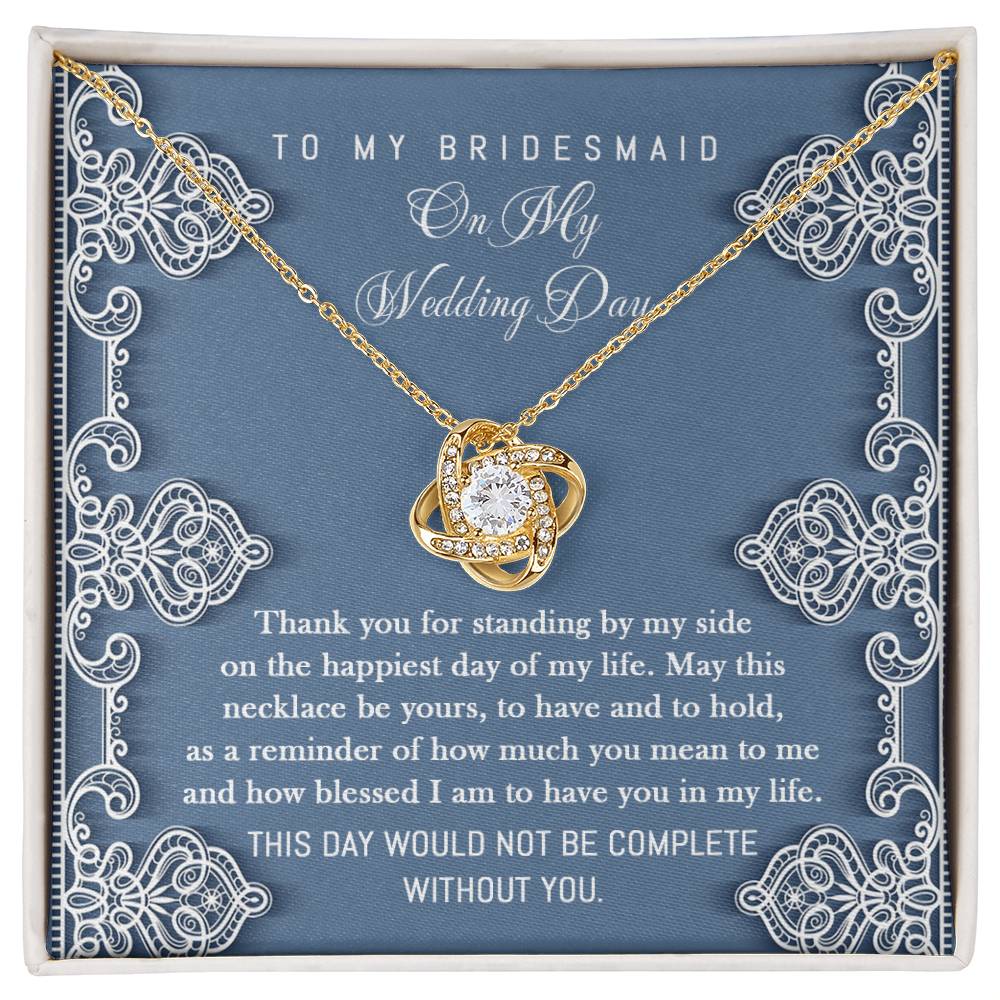 To Bridesmaid, By My Side - Love Knot Necklace with interlocking heart design, adorned with sparkling cubic zirconia crystals, displayed in a box with a heartfelt message for the bridesmaid. The message expresses gratitude for her unwavering support on the wedding day.