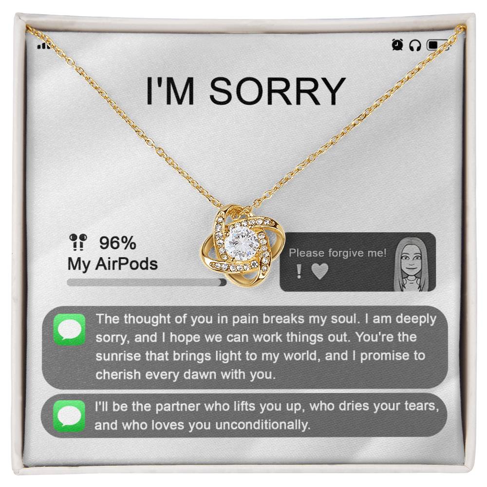 The "Sorry-Breaks My Soul - Love Knot Necklace" is a silver necklace featuring a pendant, beautifully displayed in its packaging. The front of the packaging includes a heartfelt apology message, text messages, a battery icon showing 96% for AirPods, and an illustrated figure. This intricately crafted piece is made from 14k white gold and adorned with cubic zirconia crystals.