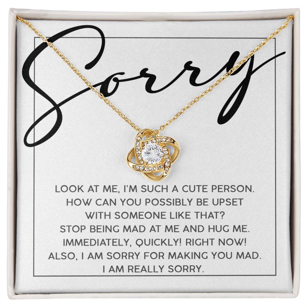 The Sorry-Someone Like That - Love Knot Necklace features a heart-shaped pendant, intricately crafted from white gold and adorned with cubic zirconia. It is beautifully placed on a card that reads "Sorry" and includes a heartfelt message seeking forgiveness.