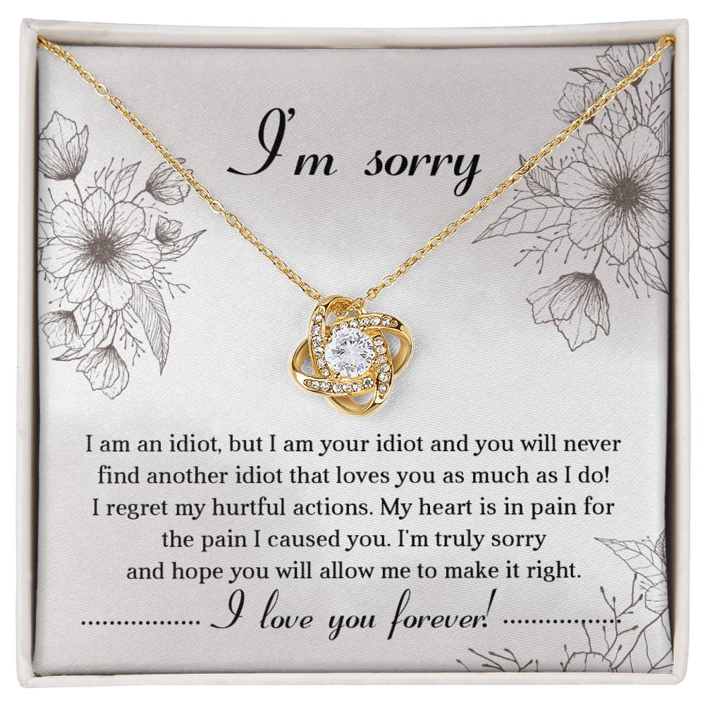 The Sorry-For The Pain - Love Knot Necklace is a personalized gift featuring a love knot pendant adorned with cubic zirconia crystals, presented on a card with an apology message expressing regret and a heartfelt plea for forgiveness, ending with "I love you forever!