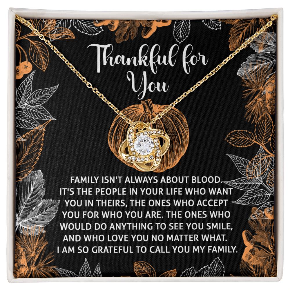 The Thanksgiving-To Call You - Love Knot Necklace, featuring a radiant white gold finish and sparkling cubic zirconia accents, is elegantly displayed on a black background surrounded by leaves and pumpkins. The text reads "Thankful for You," celebrating family and love.