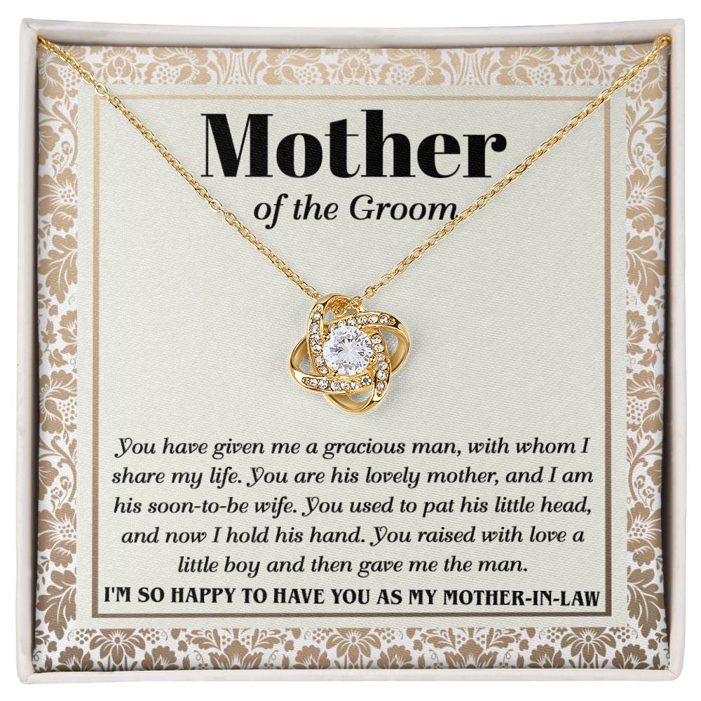 A "To Mother-In-Law, To Have You - Love Knot Necklace" with a heart-shaped pendant adorned with cubic zirconia crystals on a card labeled "Mother of the Groom" with a loving message expressing gratitude from the groom.