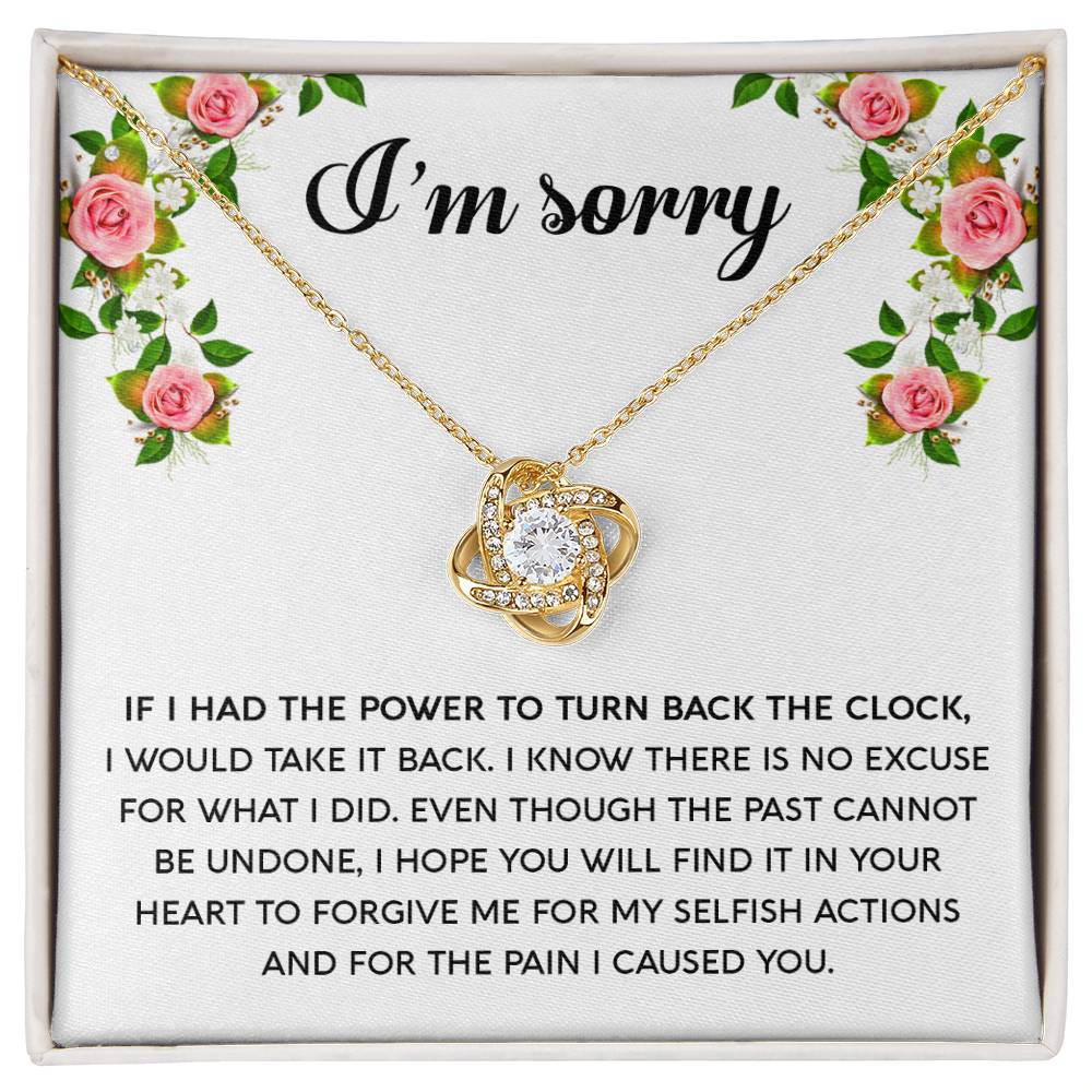 The "Sorry, Make It Right - Love Knot Necklace," featuring a silver intertwined knot pendant adorned with cubic zirconia crystals, is beautifully displayed in a box. The text on the box reads, "I’m sorry," with an apology message below, framed by a floral border in the top corners.