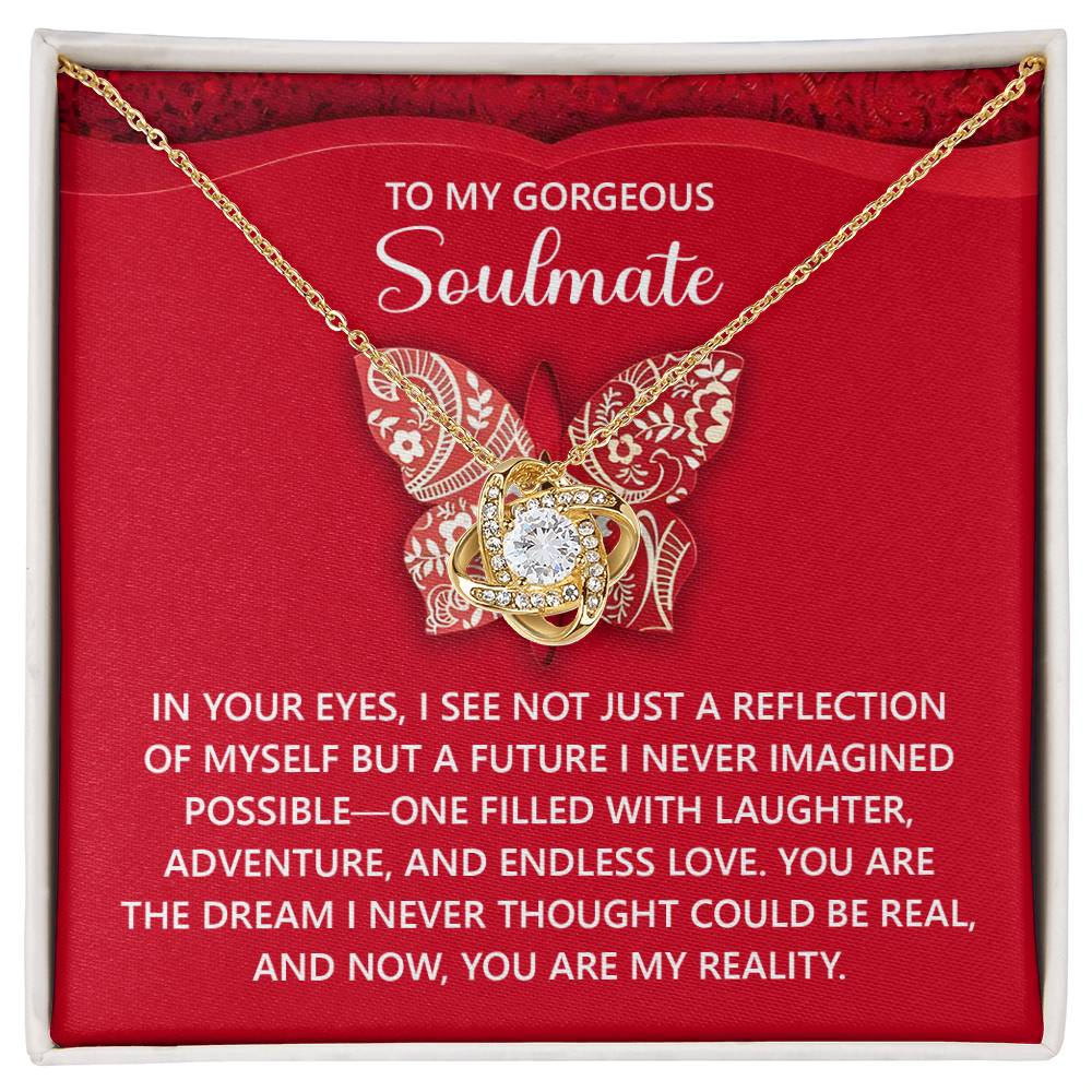 The Soulmate-My Reality Love Knot Necklace, featuring a butterfly pendant with cubic zirconia crystals, beautifully displayed on a red card that reads "To my gorgeous soulmate" with a heartfelt love message, makes an exquisite gift for your loved one.