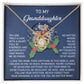 The "Granddaughter-Here For You - Love Knot Necklace," featuring a heart-shaped pendant adorned with brilliant cubic zirconia, is beautifully showcased on a card with a reindeer and holly illustration, meticulously crafted from 14k white gold, accompanied by a touching message for your granddaughter.