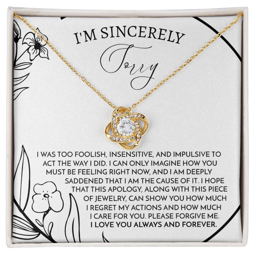 The Sorry-Care For You - Love Knot Necklace features a pendant with intertwined loops adorned with sparkling cubic zirconia crystals. It is elegantly displayed on a card that conveys an apology message, reading "I'm sincerely sorry," expressing deep regret and love.