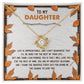Daughter-My Greatest Blessing - Love Knot Necklace, featuring a heart-shaped pendant adorned with cubic zirconia crystals and displayed in a box. The lid includes a message addressed “To My Daughter” with autumn leaves and an inspirational quote about love and life, symbolizing an unbreakable bond.