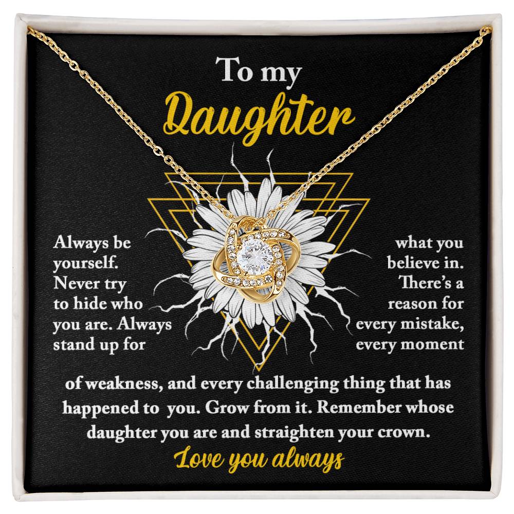 A personalized gift, this "To Daughter, Be Yourself - Love Knot Necklace" features a pendant encrusted with cubic zirconia crystals, nestled in a gift box. The box lid displays a heartfelt message addressed to "My Daughter," showcasing motivational and supportive text alongside a sunflower graphic.