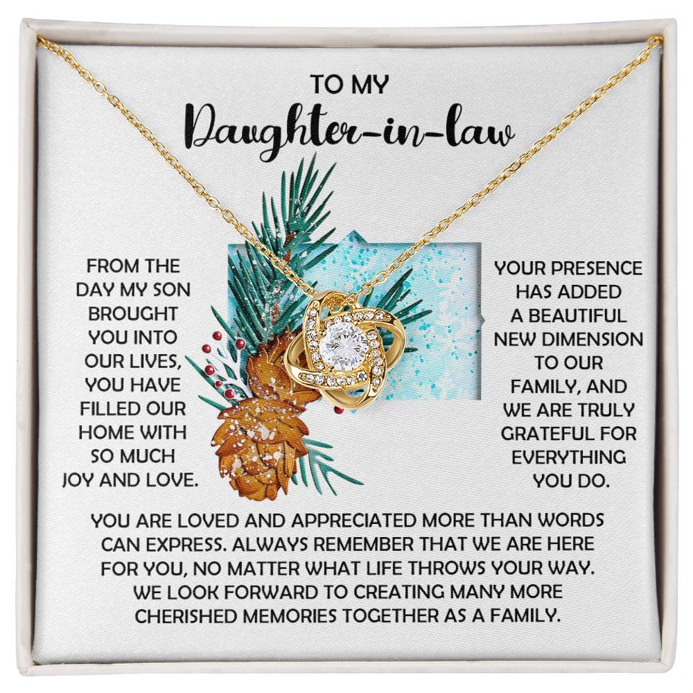 This personalized gift, the Daughter-in-Law-Here For You - Love Knot Necklace, showcases an intertwined heart pendant adorned with sparkling cubic zirconia crystals. It is elegantly presented on a card that beautifully conveys love and appreciation for a daughter-in-law.