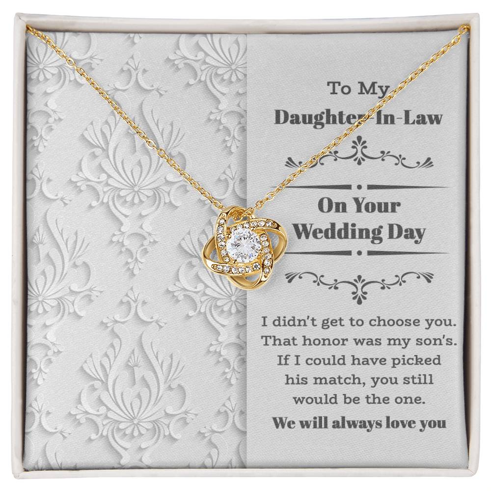 To My Daughter-In-Law Wedding, Be The One - Love Knot Necklace with an intertwined heart design, adorned with cubic zirconia crystals, displayed on a decorative backing card. The card reads: "To My Daughter-In-Law On Your Wedding Day" with a sentimental message below. Perfect as a gift for a loved one.