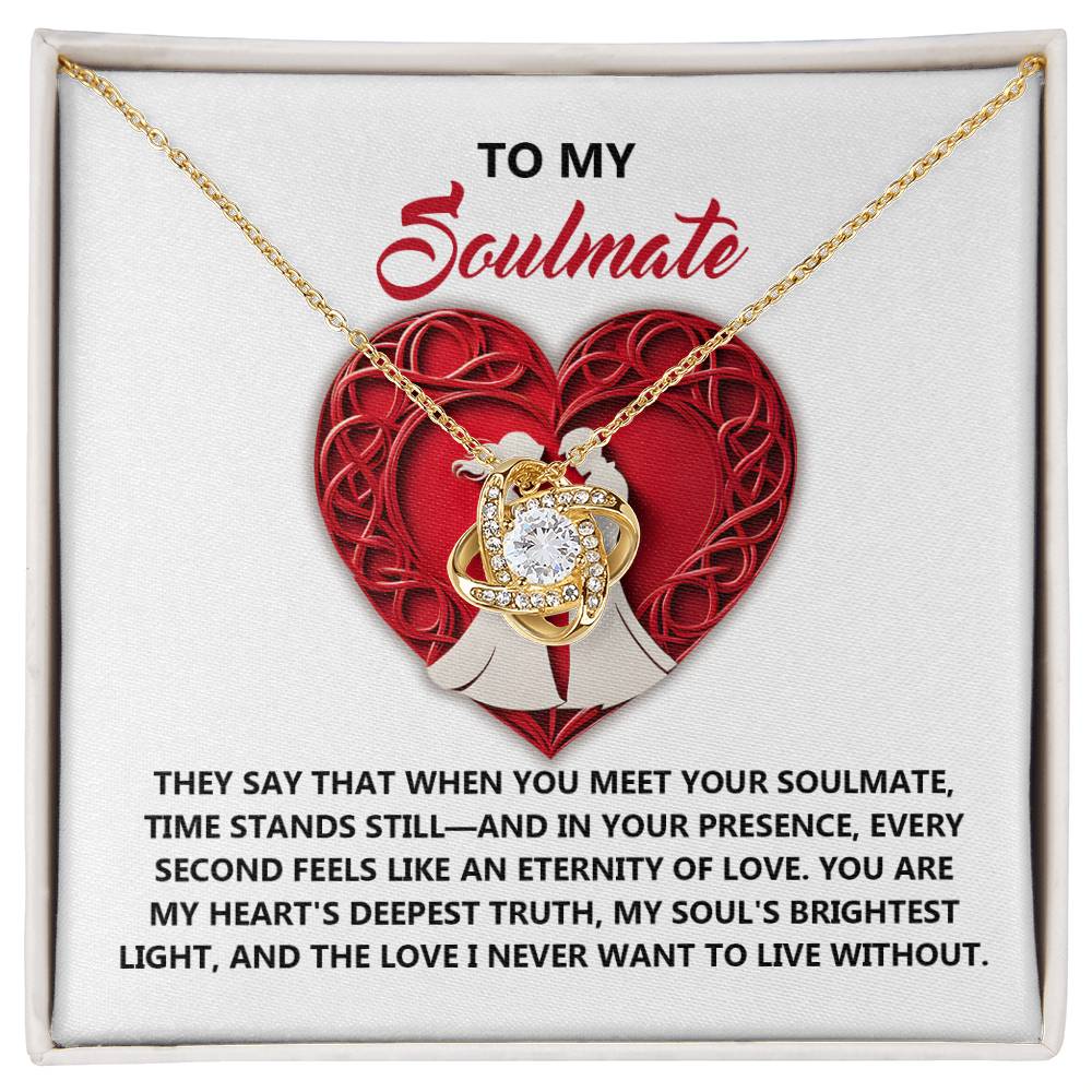 The Soulmate-Deepest Truth Love Knot Necklace features a heart and cubic zirconia pendant, elegantly displayed on a card with a red heart and the word "Soulmate," accompanied by an eloquent description of love and devotion.