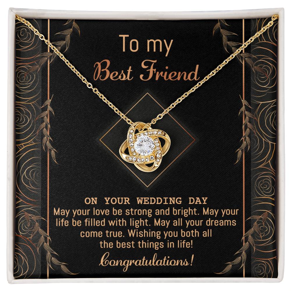 A "To Best Friend Wedding, Strong And Bright - Love Knot Necklace" adorned with cubic zirconia crystals is elegantly displayed on a black card that reads, "To my Best Friend on your wedding day. Congratulations!" The card features a decorative gold border and highlights the necklace's white gold or yellow gold finish options.