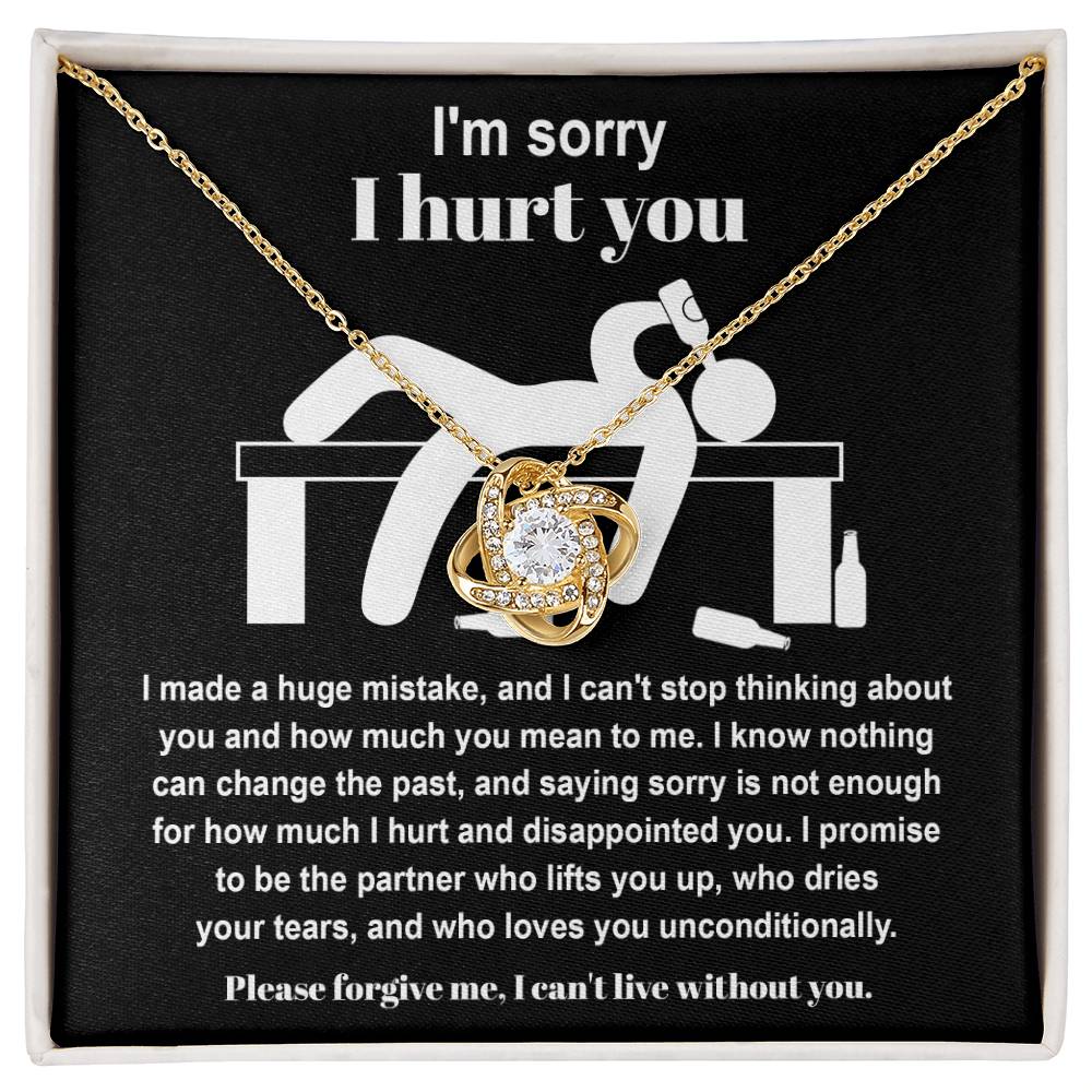 The Sorry-Change The Past 2 - Love Knot Necklace, featuring a pendant adorned with cubic zirconia crystals, is gracefully showcased on black fabric. It includes an apology message addressing past hurt and a heartfelt plea for forgiveness, complemented by illustrations of a distressed figure.